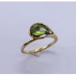 An 18ct gold ring set with a pear shaped tourmaline and single diamond