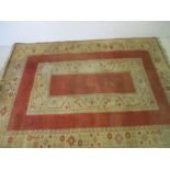 A Turkish hand made terracotta and cream rug. 272cm x 205cm