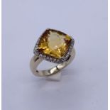 A cushion cut Citrine and diamond ring set in 18ct white gold, the centre stone approx 5-6 carats
