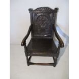 An antique Wainscott chair with carved decoration to back