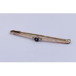 A small 9ct gold bar brooch set with a sapphire, weight 1.1g