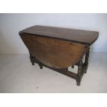 An antique oak drop leaf table with single drawer