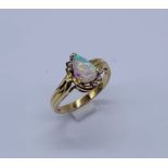 A 14ct gold ring set with a pear shaped opal and diamonds