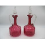 A pair of Victorian cranberry decanters , slight chip to underside of one rim, height 27.5cm