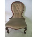 A Victorian walnut framed nursing chair with button backed detailing