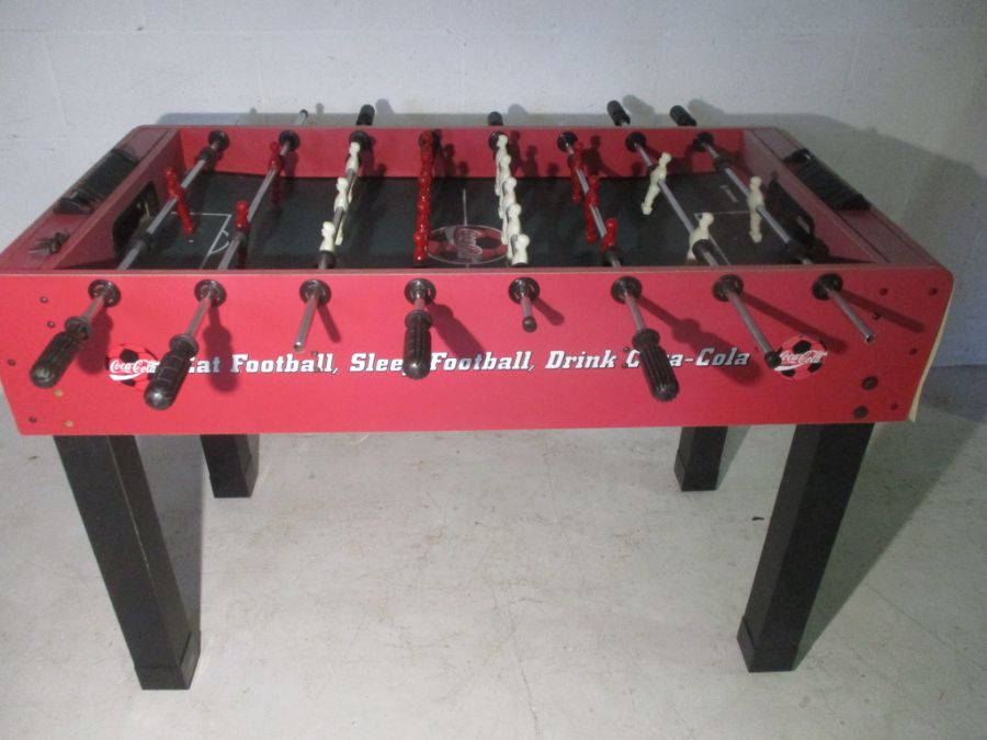 A Coca-Cola branded table football game, including five balls. One side faded by Sun.