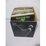 A collection of 12" vinyl records including Eric Clapton, Billy Joel, Barclay James Harvest, Dire