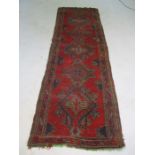 An Eastern red ground rug - approx. size 320cm x 97cm