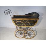 A Victorian style dolls pram with two dolls.