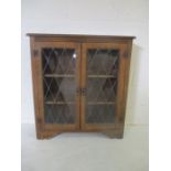 An oak dispay cabinet with ledded glass panels.