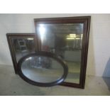 An Edwardian oval mirror 126cm x 88cm, plus two dark wooden framed mirrors.