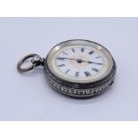 An 800 silver fob watch with floral decoration to the white enamelled dial