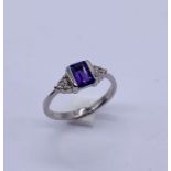 A 9ct white gold ring set with an amethyst with diamond set shoulders