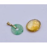 An apple jade pendant set in 14ct gold along with a loose citrine ( measuring 22mm x 1.7mm approx).
