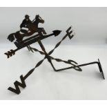 A wrought iron weather vane showing a horse and rider