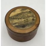 A small wooden pot with a print of Lyme Regis to the top