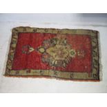 An eastern red ground rug. 94cm x 54cm