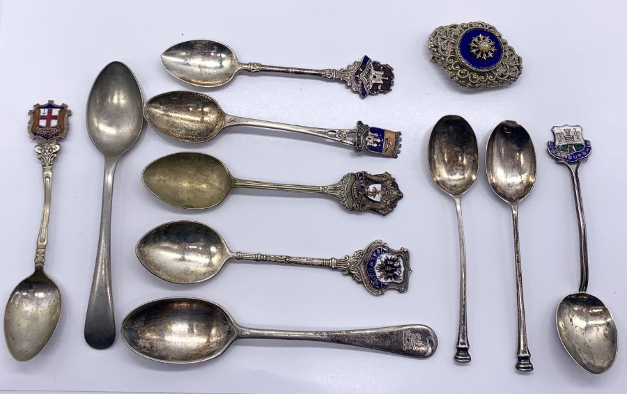 Three hallmarked silver tea spoons along with a collection of EPNS versions and a brooch