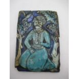 An antique Islamic moulded tile depicting a kneeing man, approx. 17cm x 12cm - A/F