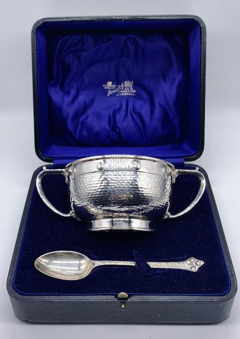 A cased Arts & Crafts hallmarked silver two handled bowl and matching spoon, hallmarked for Barker