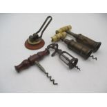 Four antique corkscrews, two brass double action, one with propeller action and one other along with