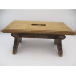 A small wooden stool with cut out hand hold