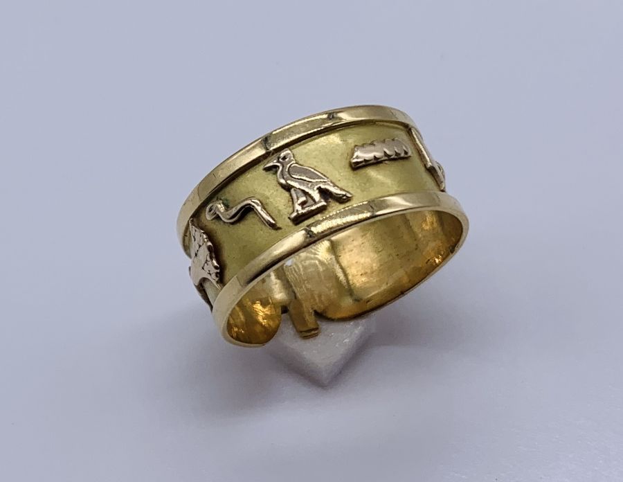 An 18ct gold (tested) Egyptian wedding band decorated with various hieroglyphs, weight 3.5g