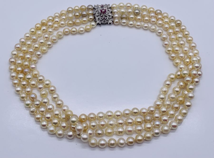 A four strand pearl necklace with an 18ct white gold clasp set with a diamond and rubies