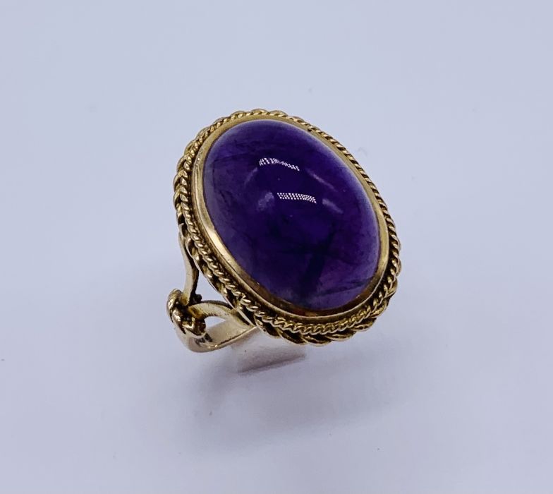 A 9ct gold ring set with a large cabochon amethyst