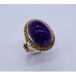 A 9ct gold ring set with a large cabochon amethyst