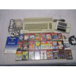 A vintage Commodore 64 computer with data cassette player, power pack and a selection of games