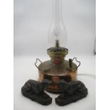 A converted copper paraffin lamp along with two cast iron door stops in the form of dogs