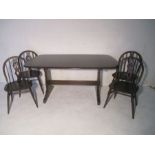 An Ercol dark wood refectory table, with four matching Ercol stick back chairs. This Lot also