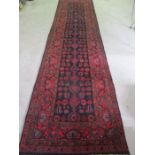 A red ground Hamadan runner, 4.3m x 104cm approx