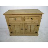 A Mexican pine sideboard with two drawers and one cupboard under