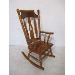 A large rocking chair with turned supports