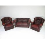 An ox-blood red leather Chesterfield three piece suite