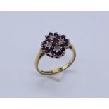 A ruby and diamond cluster ring set in 9ct gold