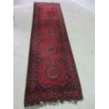 A red ground Afghan runner, 3m x 86cm