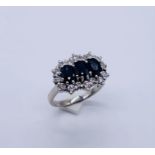 An 18ct white gold diamond and sapphire cluster ring