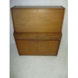 A Remploy mid century upright bureau, a drop down front with pigeon holes enclosed, over two