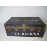 A vintage metal bound trunk, marked J.J. Haskins.