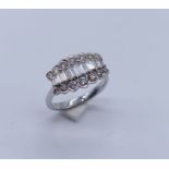 An 18ct white gold ring set with a central line of graduated baguette diamonds surrounded by two