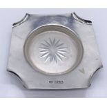 A hallmarked silver ashtray by the Goldsmiths & Silversmiths Company, London with glass liner,