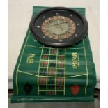 A vintage French Roulette Wheel with matching mat