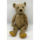 An antique straw filled plush teddy bear