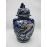An Oriental baluster vase with cover embossed with dragons, the cover surmounted by Dog of Fo -