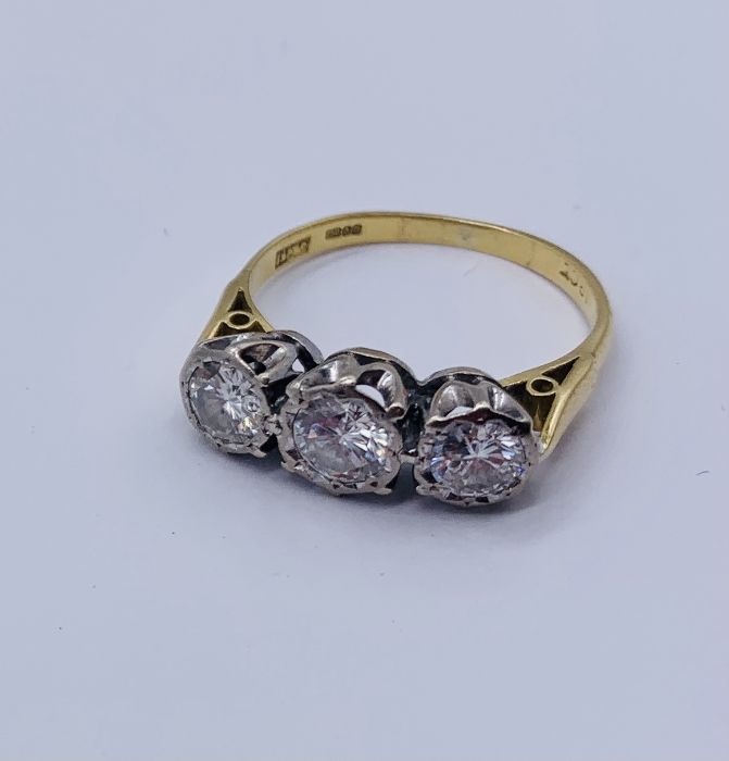 A diamond three stone ring set in 18ct gold, illusion set, the centre diamond appears to measure - Image 2 of 3