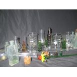 A varied assortment of glassware including poison bottles, a jar of glass stoppers, decorative and