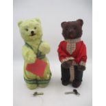 A pair of vintage clockwork bears ( male brown and female white) both dressed in Russian style